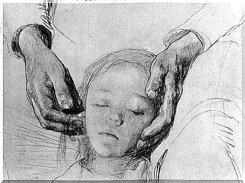 A parent's hands wrap around the child's head