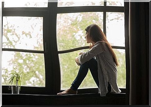 Sad woman sitting at the window