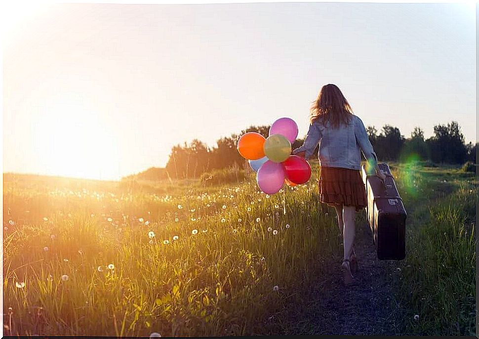 Girl with a suitcase and balloons in her hand