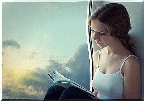 Girl reading book next to the window introverted people