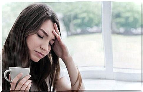 Tired woman with cup in hand.