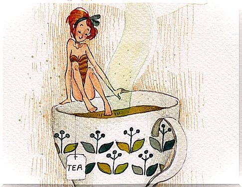 Pleased woman bathing in a cup of tea