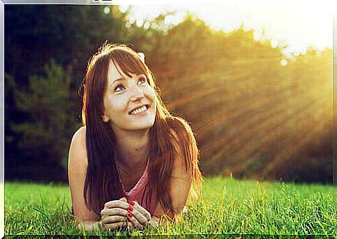 Optimism and health, girl looks at the sun and smiles