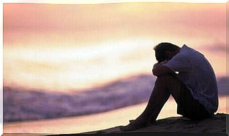 Sad man sitting in front of the sea.