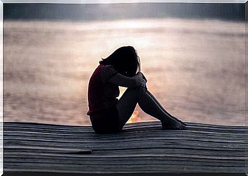 Teenage girl crying on a pier