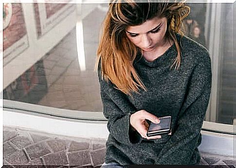 Pensive woman with phone in hand.