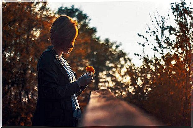 Woman with orange flower in her hand